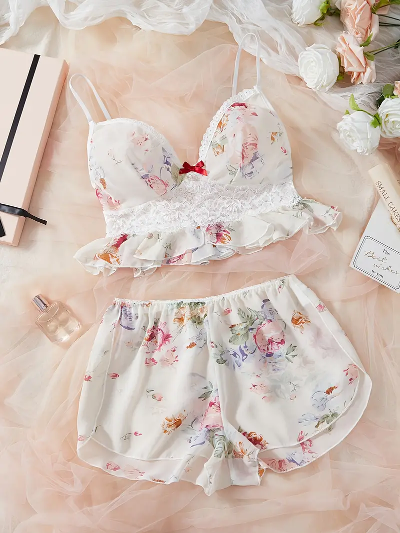 Floral lace ruffle-trim bralette with adjustable straps paired with matching floral print sleep shorts on soft tulle backdrop.